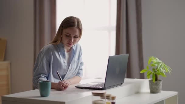Concentrated focused woman student or freelancer working at laptop in cafe or coworking. remote work, self employment and study, solving task, research — Stock Video