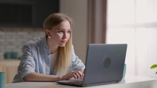 Mobiel kantoor thuis. Een jonge vrouw die thuis in de keuken werkt met een laptop. Lifestyle meisje studeren of werken binnen. Quarantaineconcept voor freelance bedrijven — Stockvideo