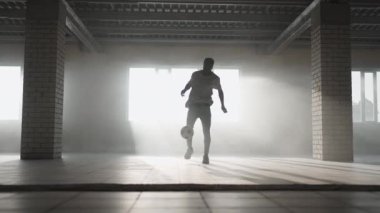 Futbol serbest stili ağır çekim. Genç siyah adam yeraltı otoparkında futbol topuyla antrenman yapıyor. Genç bir Afrikalı Amerikalının futbol oyuncusu olma hayali üzerine antrenörlük yapması ve çalışması.