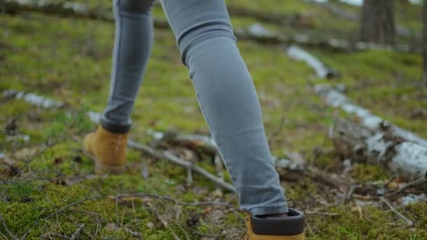 女性小腿以慢动作攀登陡峭的地形。走在秋天路上的远足靴中。女人们的脚步声在秋天的室外追踪，穿过林地 — 图库视频影像