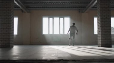 Zenci futbolcu futbolcu, içi boş bir otoparkta top oynarken, tekmeler ve hareketler yapıyor. Afrikalı çocuk Urban City 'de serbest stil eğitimi alıyor. Yavaş çekim RAW derecelendirilmiş görüntüler