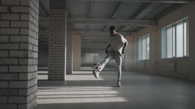 Futbol serbest stili ağır çekim. Genç siyah adam yeraltı otoparkında futbol topuyla antrenman yapıyor. Genç bir Afrikalı Amerikalının futbol oyuncusu olma hayali üzerine antrenörlük yapması ve çalışması.