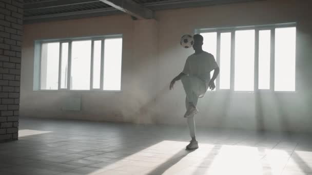 Zenci futbolcu futbolcu, içi boş bir otoparkta top oynarken, tekmeler ve hareketler yapıyor. Afrikalı çocuk Urban City 'de serbest stil eğitimi alıyor. Yavaş çekim RAW derecelendirilmiş görüntüler — Stok video