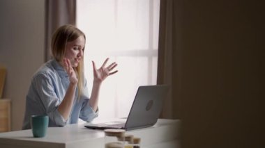 Bilgisayarlı mutlu kadın video konferansı yapıyor. Genç bir kadın bir arkadaşıyla mutfakta cep telefonuyla video görüşmesi yapıyor. Kadın video konferansını merkez ofiste başlat, el salla ve selamla.