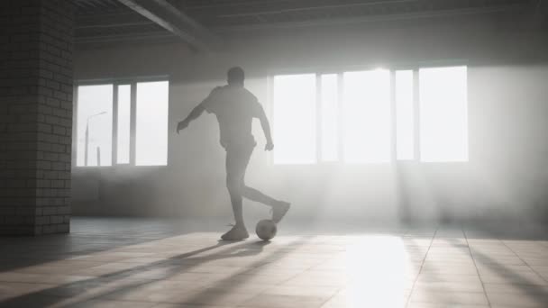 Adolescente jogador de futebol praticando truques, chutes e movimentos com bola dentro vazio garagem coberta. Estilo de vida urbano cidade ao ar livre concepto — Vídeo de Stock