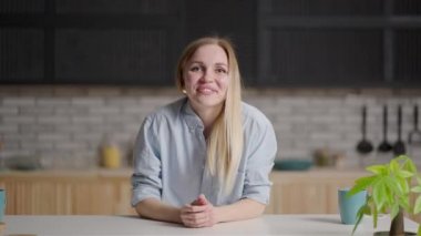 Kameraya bakan kız dans ediyor ve ellerini sallıyor ve elleriyle bir jest yapıyor. Kalbine doğru.