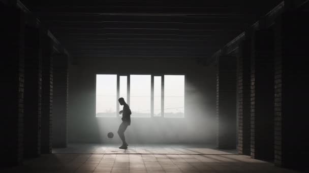 Hombre negro de fútbol estilo libre al sol. Futbolista profesional hace malabares pelota en aparcamiento subterráneo — Vídeo de stock