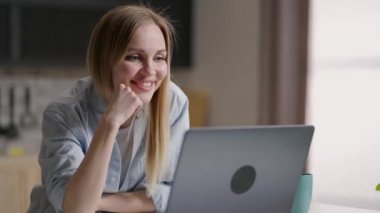 Bilgisayarlı mutlu kadın video konferansı yapıyor. Genç bir kadın bir arkadaşıyla mutfakta cep telefonuyla video görüşmesi yapıyor. Kadın video konferansını merkez ofiste başlat, el salla ve selamla.