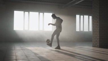 Zenci futbolcu çocuk top ile oyun, tekme ve hareketler yapıyor içi boş bir otoparkta. Yavaş çekim Şehir yaşam tarzı