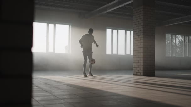 Teenager boy football soccer player practicing tricks, kicks and moves with ball inside empty covered parking garage. Urban city lifestyle outdoors concepte — Stock Video