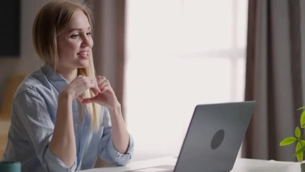Bilgisayarlı mutlu kadın video konferansı yapıyor. Genç bir kadın bir arkadaşıyla mutfakta cep telefonuyla video görüşmesi yapıyor. Kadın video konferansını merkez ofiste başlat, el salla ve selamla. — Stok video