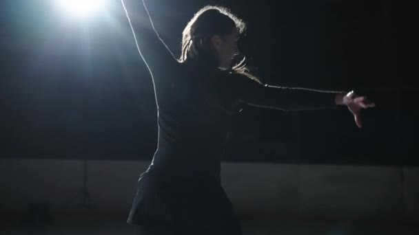 Повільний рух: Кінематографічний знімок молодої жінки-художнього фігуриста виконує одиночну хореографію на ковзанах перед початком змагань. Концепція свободи — стокове відео
