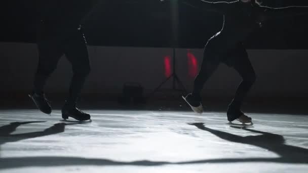 Pair figure skating on the rink. A man and a woman in a counter-light perform elements of the Olympic program together in slow motion — Stock Video