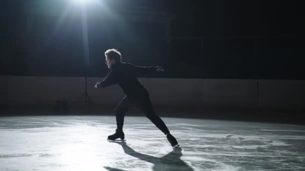 El patinador artístico masculino profesional realiza un complejo elemento de patinaje artístico sin problemas. Atleta realiza un salto beduino en el entrenamiento. Joven realiza un salto de mariposa en patinaje artístico. salto de patinaje. — Vídeos de Stock