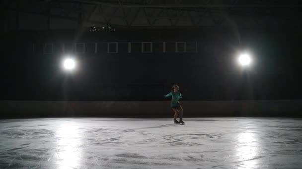 A menina patinadora realiza um salto com a rotação de um laço de dedo do pé triplo em uma luz de contador em um gato de gelo. Salto em câmera lenta na patinação artística — Vídeo de Stock