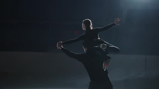Professionelle Skater in den Gegenkurven ein Paar Männer und Frauen führen eine Rotation, der Mann hebt das Mädchen auf den Arm und dreht zusammen auf Skates in Zeitlupe — Stockvideo