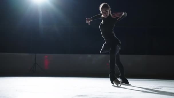 Slow motion: Toma cinematográfica de una joven patinadora artística femenina que realiza una coreografía de patinaje femenino en pista de patinaje sobre hielo antes de comenzar una competición. Concepto de libertad — Vídeos de Stock