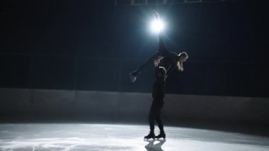 Yavaş çekim: genç artistik patinajcılar yarışma başlamadan önce buz pateni pistinde çift olarak koreografi yapıyorlar. Mükemmellik kavramı, kesinlik, özgürlük, tutku