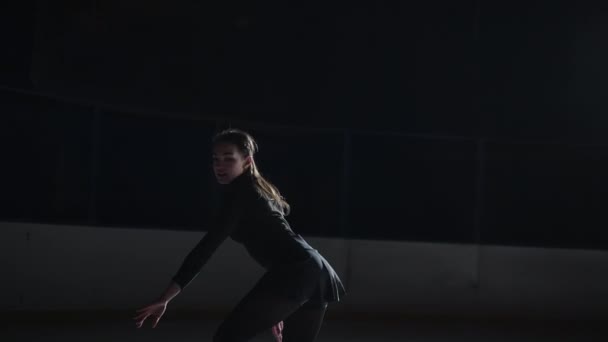 Vrouwelijke kunstzinnige kunstschaatsster voert voor de start van een wedstrijd een enkele schaatschoreografie op de ijsbaan uit voor vrouwen. Langzame beweging 120 fps. Concept van perfectie, precisie, vrijheid, passie — Stockvideo