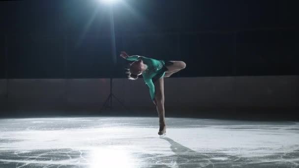 Jovem graciosa executa os elementos básicos de patinação artística, girar de pé sobre patins — Vídeo de Stock