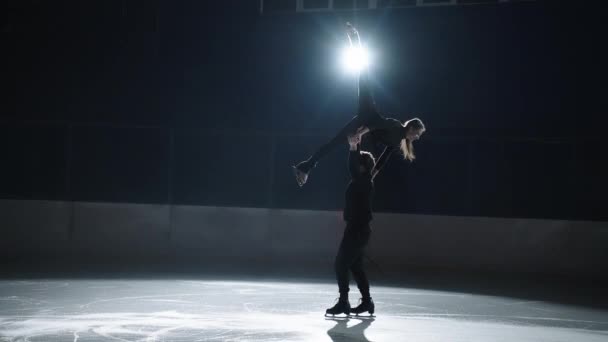 Movimento lento: jovem casal de patinadores artísticos está realizando uma coreografia de patinação dupla na pista de gelo antes do início de uma competição. Conceito de perfeição, precisão, liberdade, paixão — Vídeo de Stock