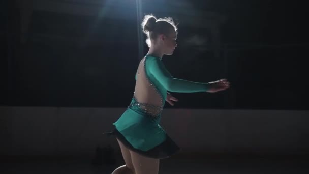 A lány korcsolyázó csinál egy ugrás a forgatás egy hármas lábujj hurok egy pult fény egy jeges macska. Lassított mozgású ugrás műkorcsolyázásban — Stock videók