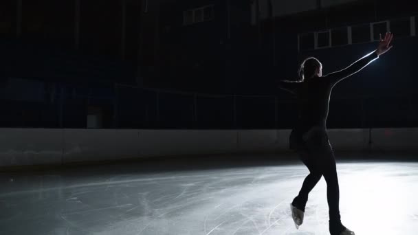 La patineuse artistique féminine exécute une chorégraphie de patinage simple féminine sur une patinoire avant le début d'une compétition. Ralentissez 120 ips. Concept de perfection, précision, liberté, passion — Video