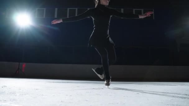 Повільний рух: Кінематографічний знімок молодої жінки-художнього фігуриста виконує одиночну хореографію на ковзанах перед початком змагань. Концепція свободи — стокове відео