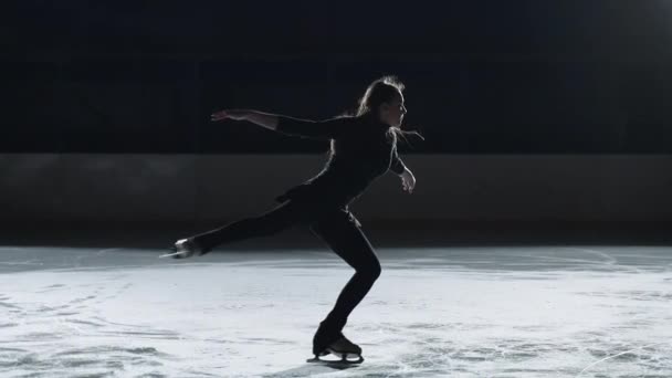 Slow motion: Toma cinematográfica de una joven patinadora artística femenina que realiza una coreografía de patinaje femenino en pista de patinaje sobre hielo antes de comenzar una competición. Concepto de libertad — Vídeos de Stock