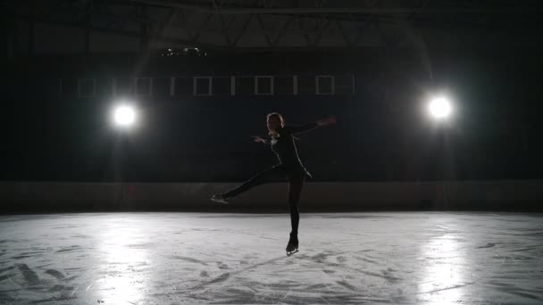 Trening na łyżwach na krytym lodowisku. Jazda figurowa na stadionie. Kobieta wykonuje elementy łyżwiarstwa figurowego, Layback Spin. — Wideo stockowe