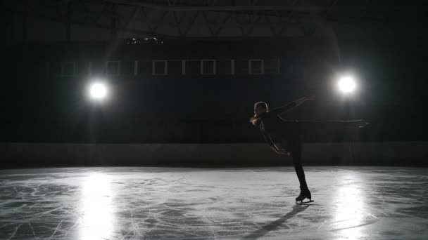 Slow motion: Toma cinematográfica de una joven patinadora artística femenina que realiza una coreografía de patinaje femenino en pista de patinaje sobre hielo antes de comenzar una competición. Concepto de libertad — Vídeos de Stock