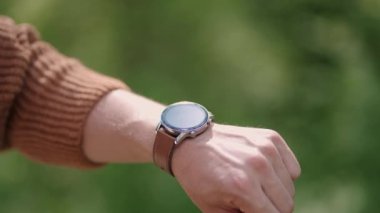 GPS 'i senkronize etmek ve ayarlamak için akıllı saati telefonunu kullanıyor. Modern teknoloji saatle yön buluyor. Etkinlik kontrolü