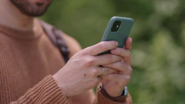 Nahaufnahme eines Mobiltelefons in den Händen eines männlichen Reisenden, der durch den Wald geht. Soziale Netzwerke Navigator und Messenger. Benutzen Sie Ihr Handy für einen Waldspaziergang — Stockvideo