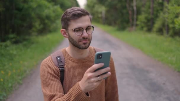 Młody człowiek w okularach, turysta z brodą kręci film przez telefon z podróży w zwolnionym tempie. — Wideo stockowe