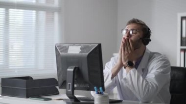 Erkek doktor baş ağrısı çekiyor. Yorgun bir doktor portresi. Doktor işten sonra yorgun ve başı ağrıyor.