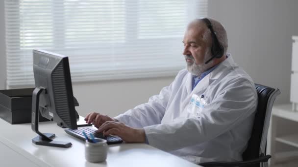 Les types de médecins masculins surchargés sur un clavier d'ordinateur ressentent alors des maux de tête tout en étant assis à une table avec. travailler avec la dactylographie informatique assis au bureau — Video