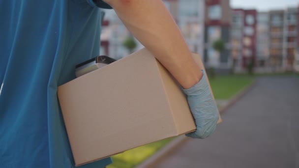 El cartero o el hombre de la entrega llevan la pequeña caja entrega al cliente en el pago sin contacto del terminal del nfc del hogar. — Vídeos de Stock