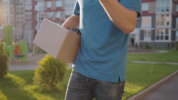 Entrega A mão do jovem paga por compras usando o sistema nfs de pagamento sem contato. Jovem entrega homem segurar pacote homem cliente pagando por telefone para o transporte de encomendas ordem expressa uniforme de pagamento — Vídeo de Stock