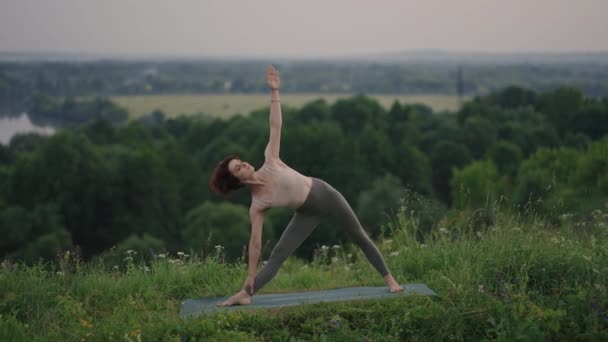 Hermosa joven realizando una pose de yoga espiritual en la cima de una montaña en cámara lenta, zen wellness — Vídeos de Stock