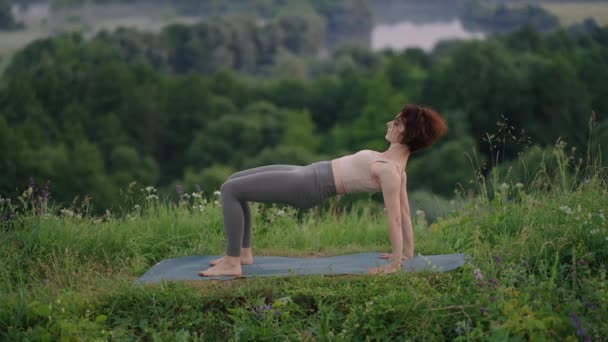 Hermosa joven realizando una pose de yoga espiritual en la cima de una montaña en cámara lenta, zen wellness — Vídeo de stock