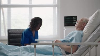 Esmer tenli bir kadın doktor, eski bir erkek hastayla konuşuyor. Hastanede yatıyor ve iyileştikten sonra rehabilitasyonu tartışıyorlar..