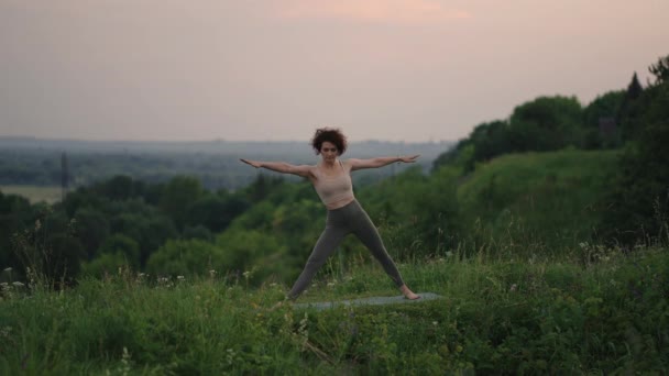 Kvinna som gör yoga i Hawaii bergen mediterar. Ung kvinna övar yoga på vacker exotisk plats på toppen av ett berg i slow motion. Yoga och meditation. — Stockvideo