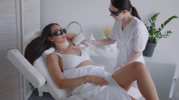 Una cosmetologa donna fa la depilazione laser delle ascelle in un salone di bellezza. Rimozione dei peli dalle ascelle. Bellezza e pelle pulita — Video Stock