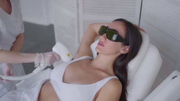 Una cosmetologa donna fa la depilazione laser delle ascelle in un salone di bellezza. Rimozione dei peli dalle ascelle. Bellezza e pelle pulita — Video Stock