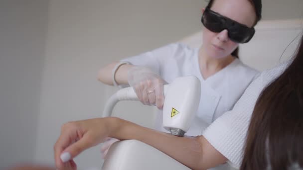 Procedura di rimozione dei capelli a portata di mano. Depilazione laser su un laser a diodi, monitoraggio telecamera in movimento. Il cosmetologo di donna applica il gel di depilazione laser a mano femminile. fotoepilazione, concetto di cura del corpo. — Video Stock