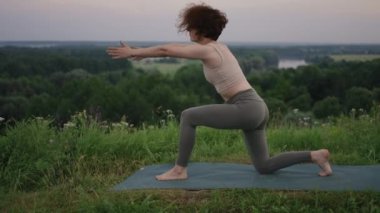 Yoga ustası denge ve ruh gelişimi için çeşitli egzersizler ve hareketler yapar. Sabahın erken saatlerinde ormanın dağlarında ağır çekimde ayakta durur.