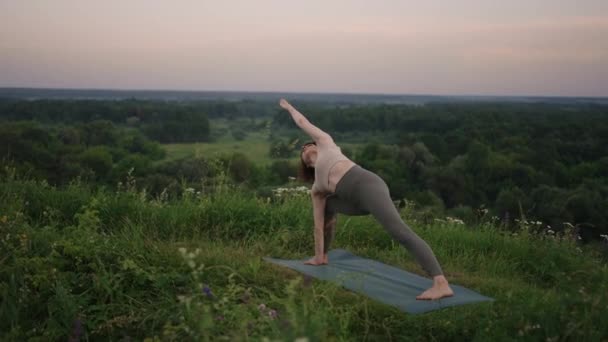 Bella ragazza che fa yoga e pilates nella foresta di montagna. Fitness girl training all'aria aperta nel paesaggio della natura. — Video Stock