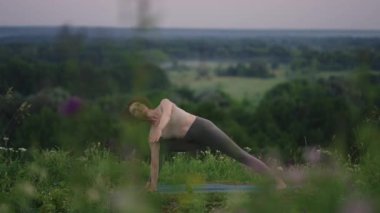 Yoga ustası denge ve ruh gelişimi için çeşitli egzersizler ve hareketler yapar. Sabahın erken saatlerinde ormanın dağlarında ağır çekimde ayakta durur.