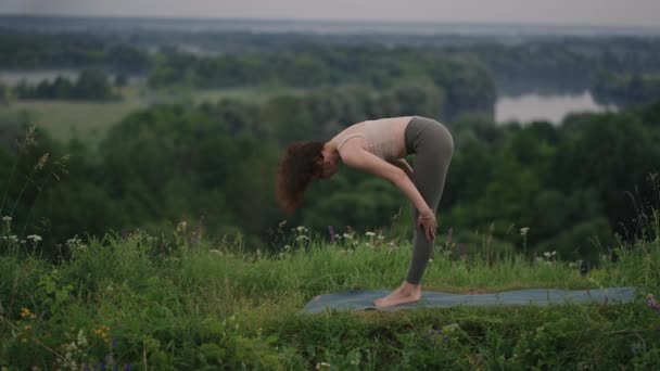 Jolie fille qui fait du yoga et du pilates dans la forêt de montagne. Fitness girl formation en plein air dans le paysage de la nature. — Video