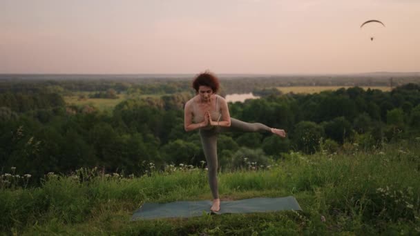 Linda chica haciendo yoga y pilates en el bosque de montaña. Chica fitness entrenamiento al aire libre en el paisaje de la naturaleza. — Vídeos de Stock